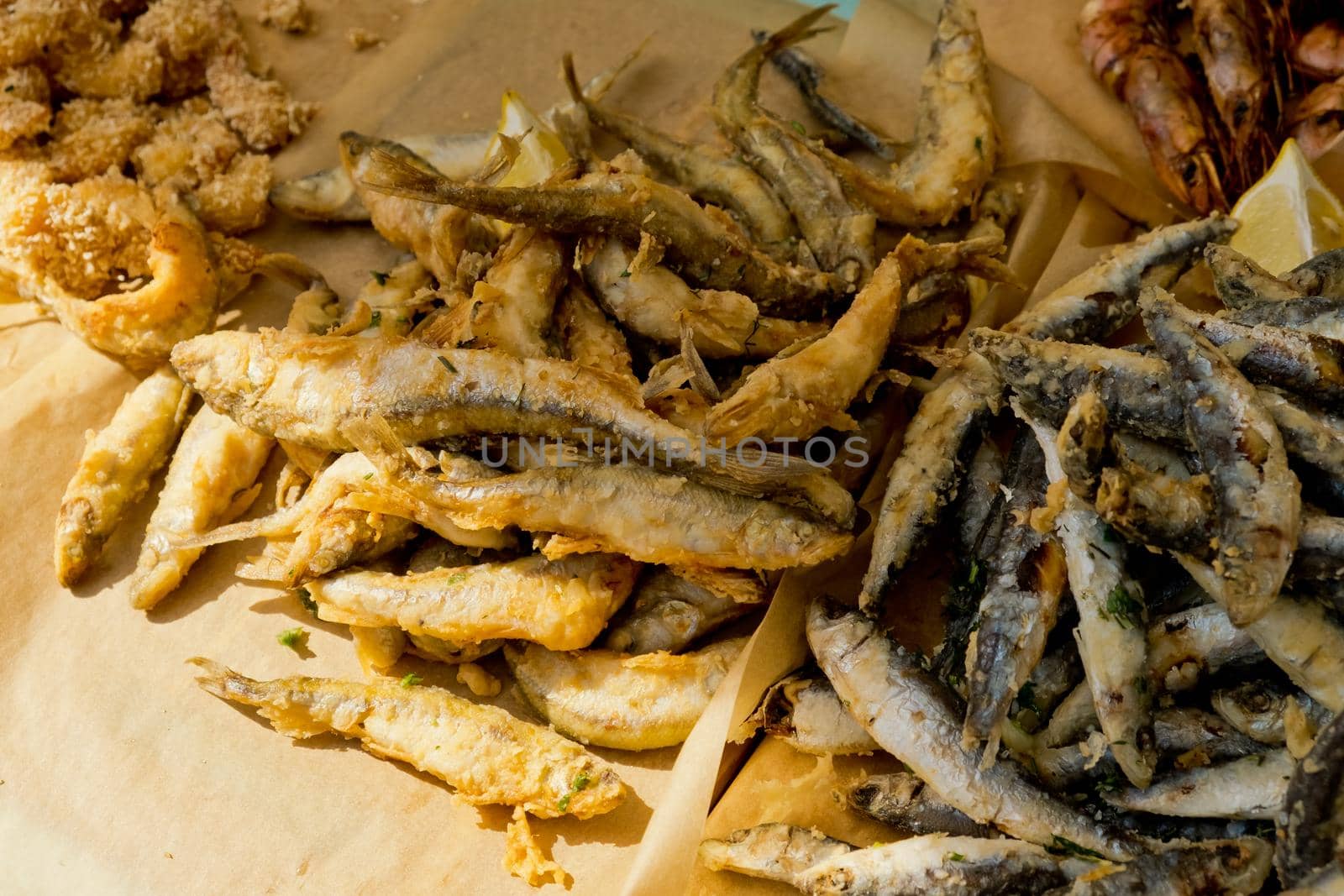 Small fried fish on the counter. Street food festival. Selective focus. Close-up.