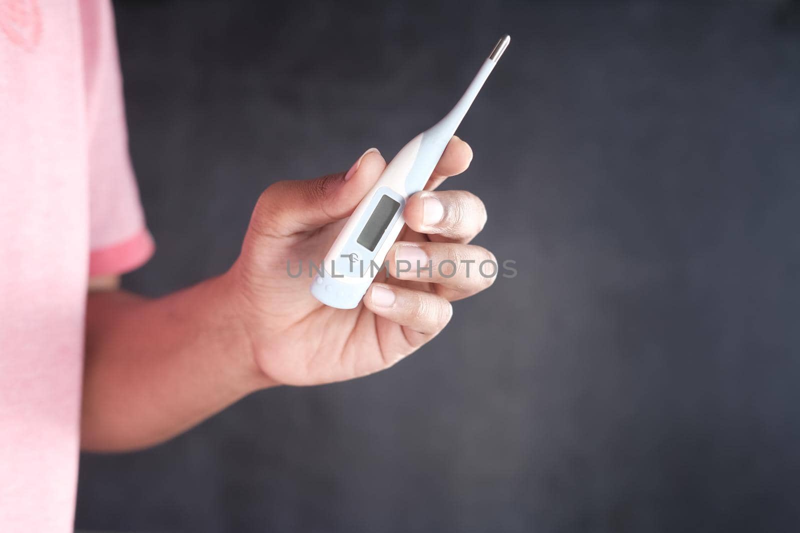 close up of man hand holding digital thermometer. by towfiq007