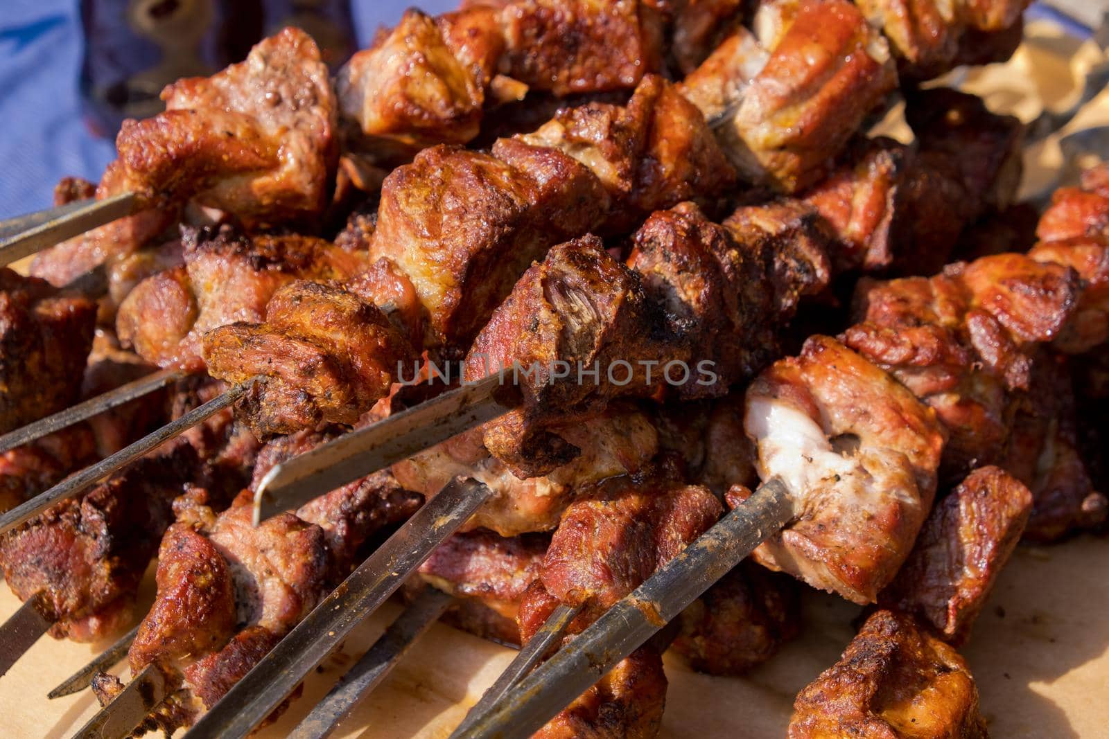 Fried kebab on skewers. Street food festival. Close-up. Selective focus. by leonik