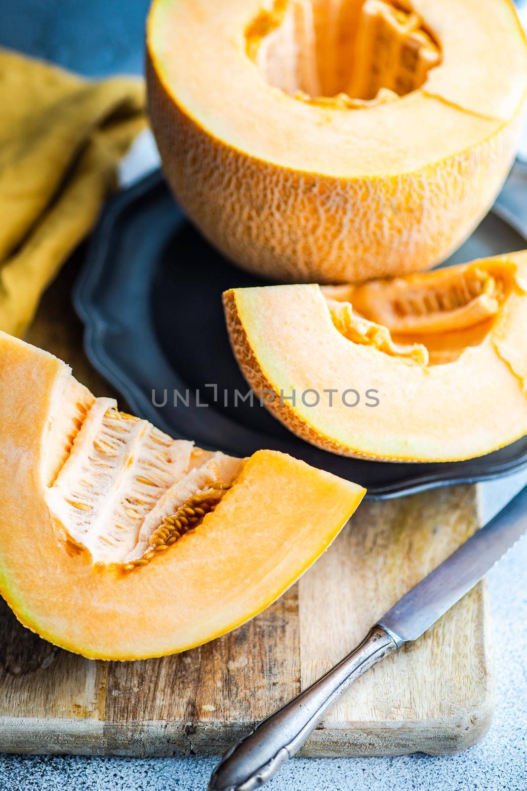 Ripe and tasty melon cut in slices and served for dessert on table