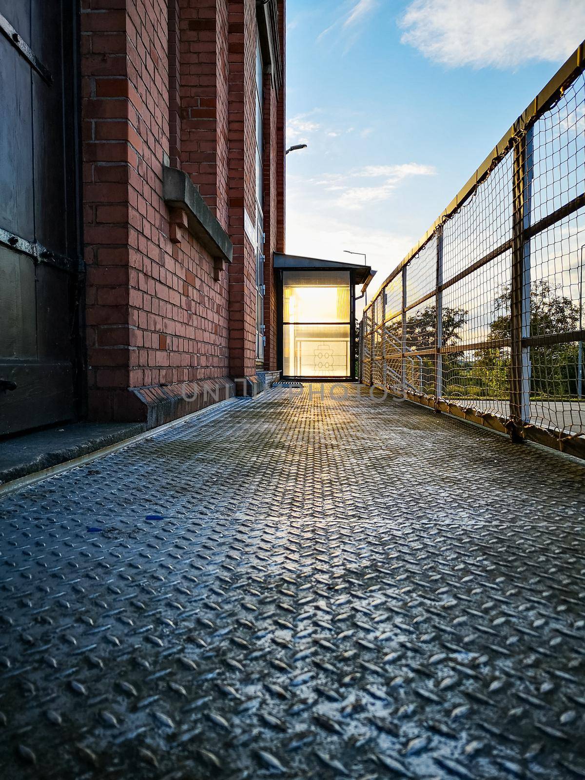 Shadow of metal railing on transparent plastic looks like glass at the end of long steel ramp by Wierzchu