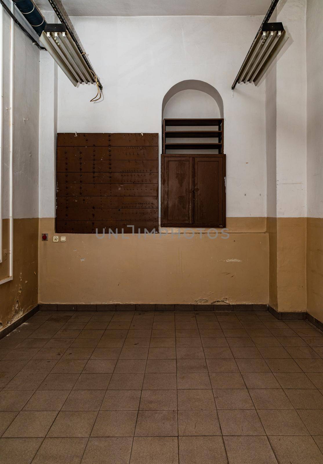 Interior of small room with wooden doors of cupboards on white and brown wall by Wierzchu