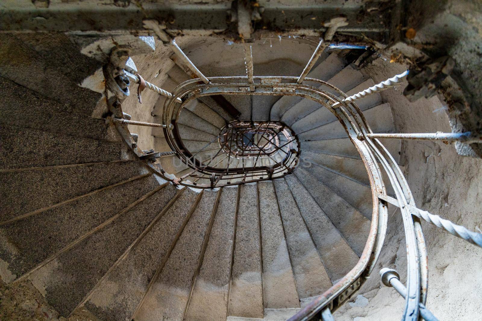 Gray spiral concrete staircase in old high building