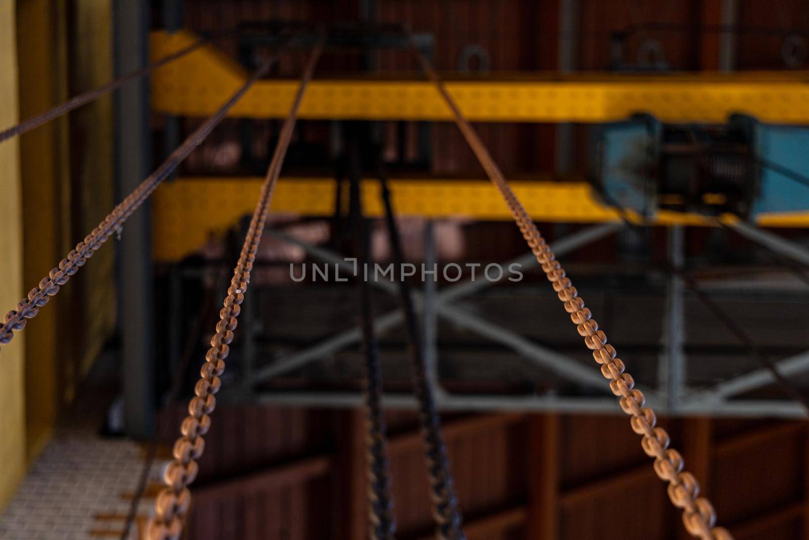 Upward view to long steel chains hanged on steel constructions by Wierzchu