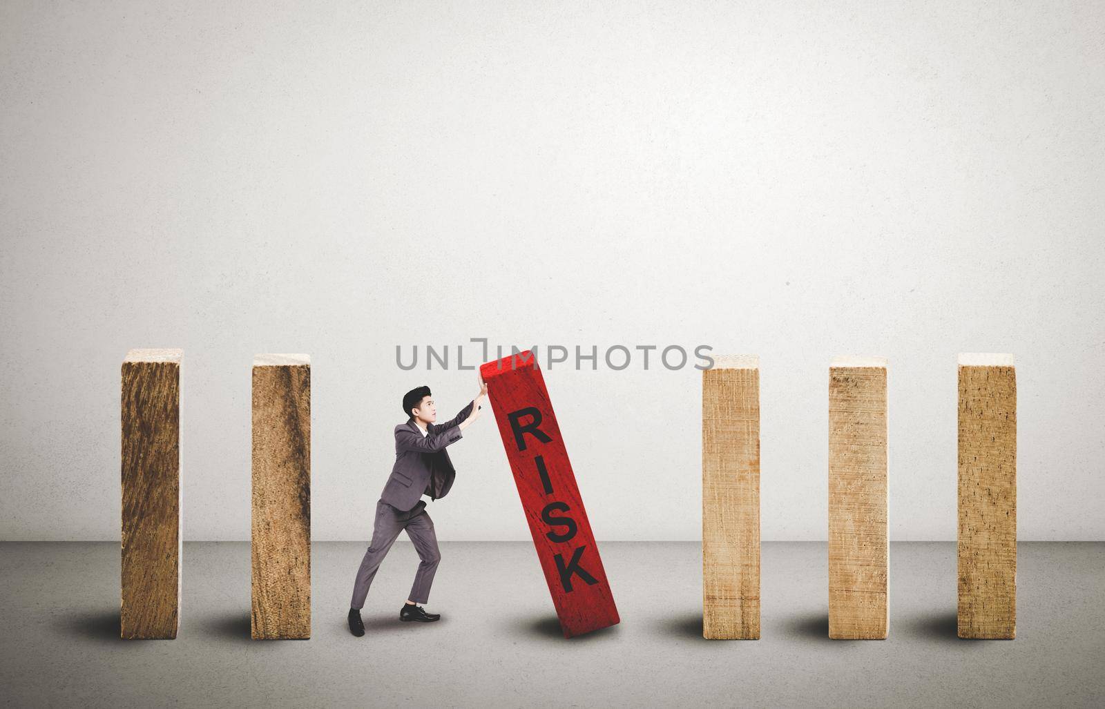 Risk of investment with economy, businessman push and stop wooden block domino with falling, management of strategy for prevention of bankruptcy, financial and insurance, crisis of business concept. by nnudoo