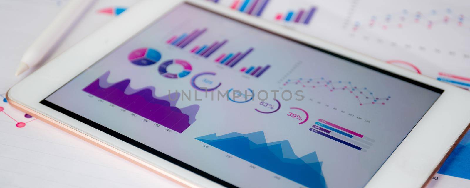 Report graph and chart of investment with finance on tablet computer on desk, datum of stock and growth, planning and statistic with economic, no people, digital marketing, business concept. by nnudoo