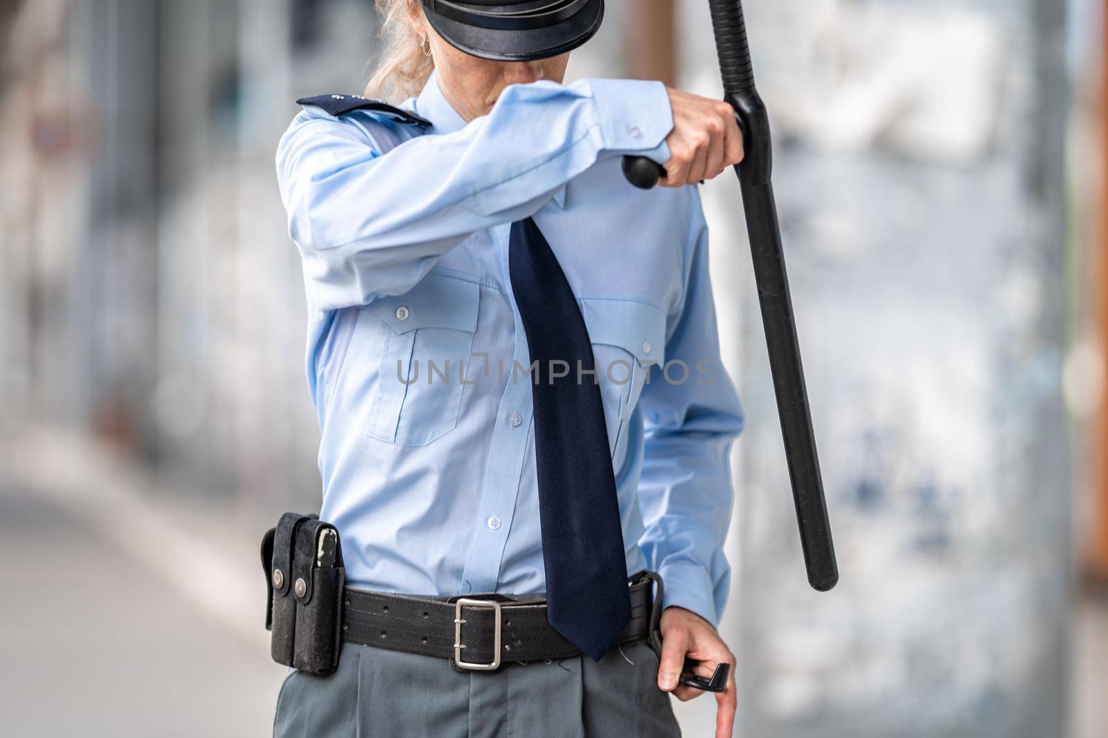 policewoman with a baton in her hand in the street.