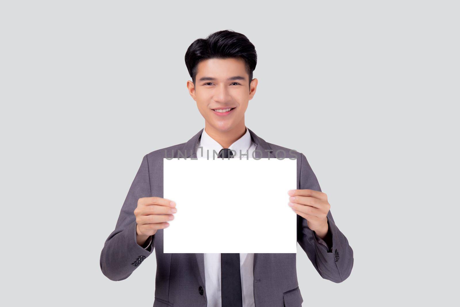 Young asian business man showing empty signboard for advertising isolated on white background, businessman confident holding billboard banner for presenting with copy space, success and achievement.