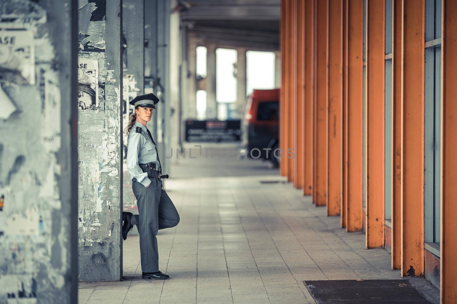 policewoman in uniform walking around the city district by Edophoto