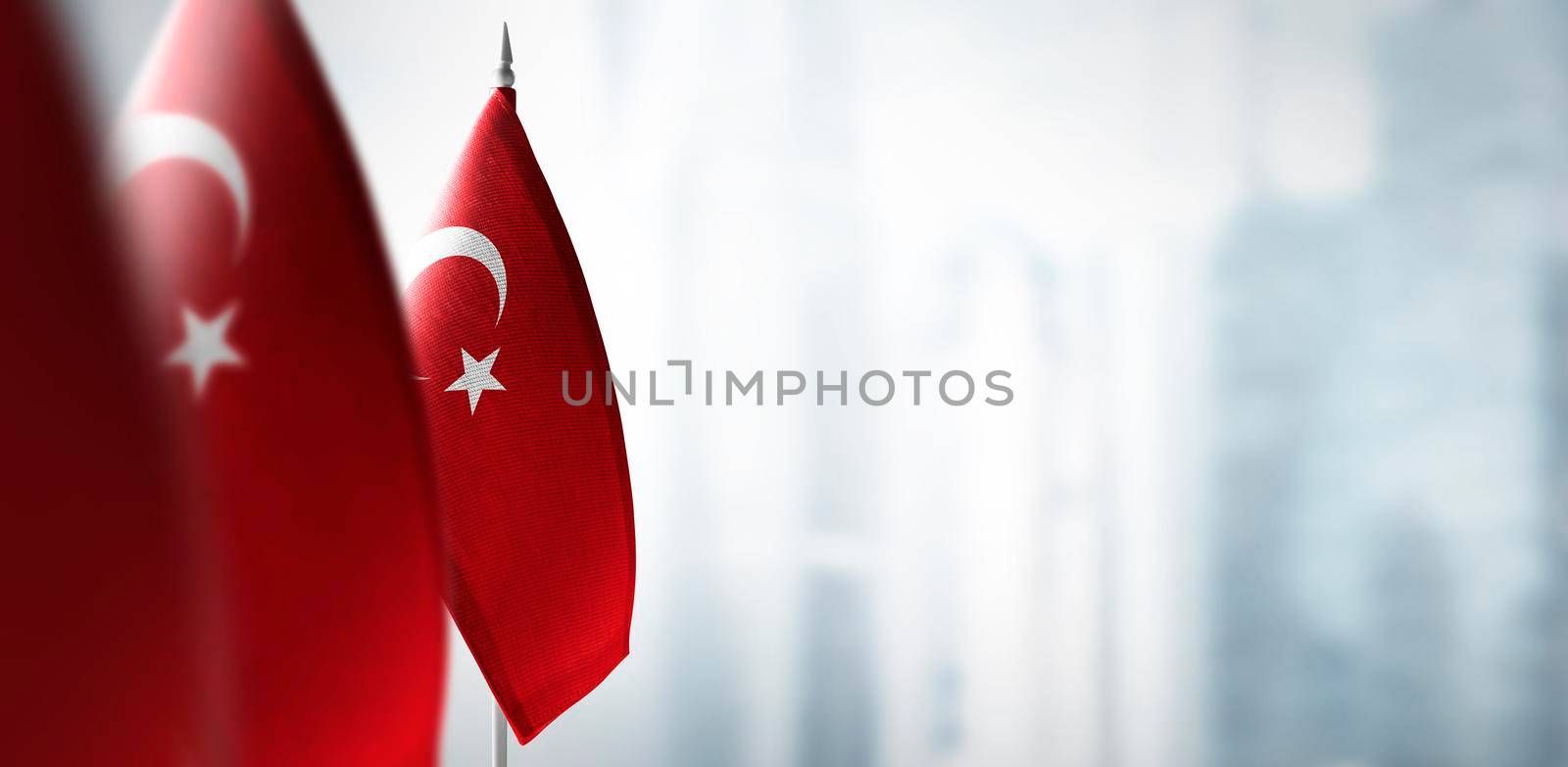 Small flags of Turkey on a blurry background of the city by butenkow