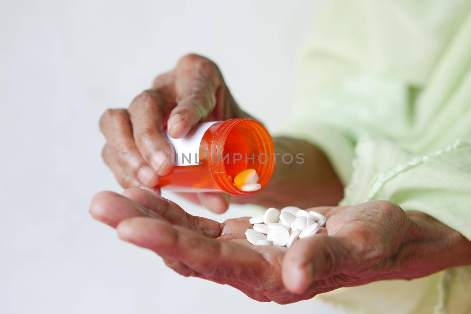 close up of pills and capsule on senior women's hand by towfiq007