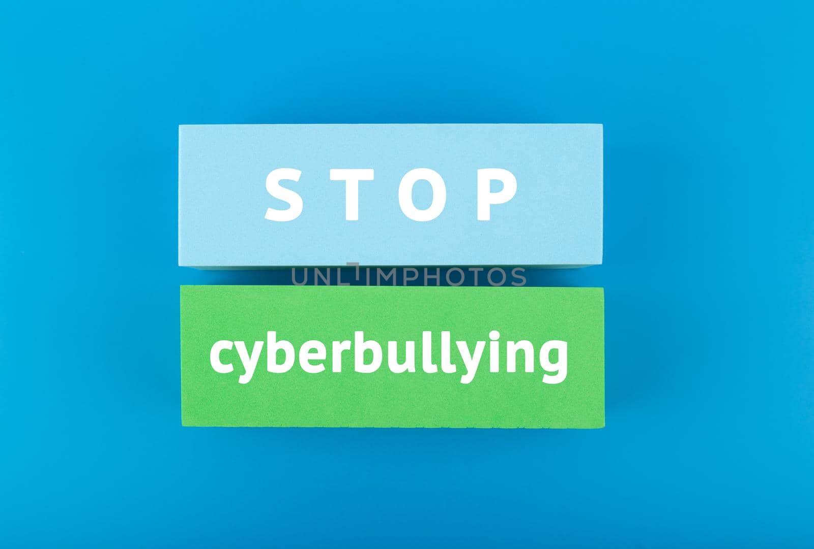 Stop cyberbullying concept. Minimal flat lay with text on blue background by Senorina_Irina