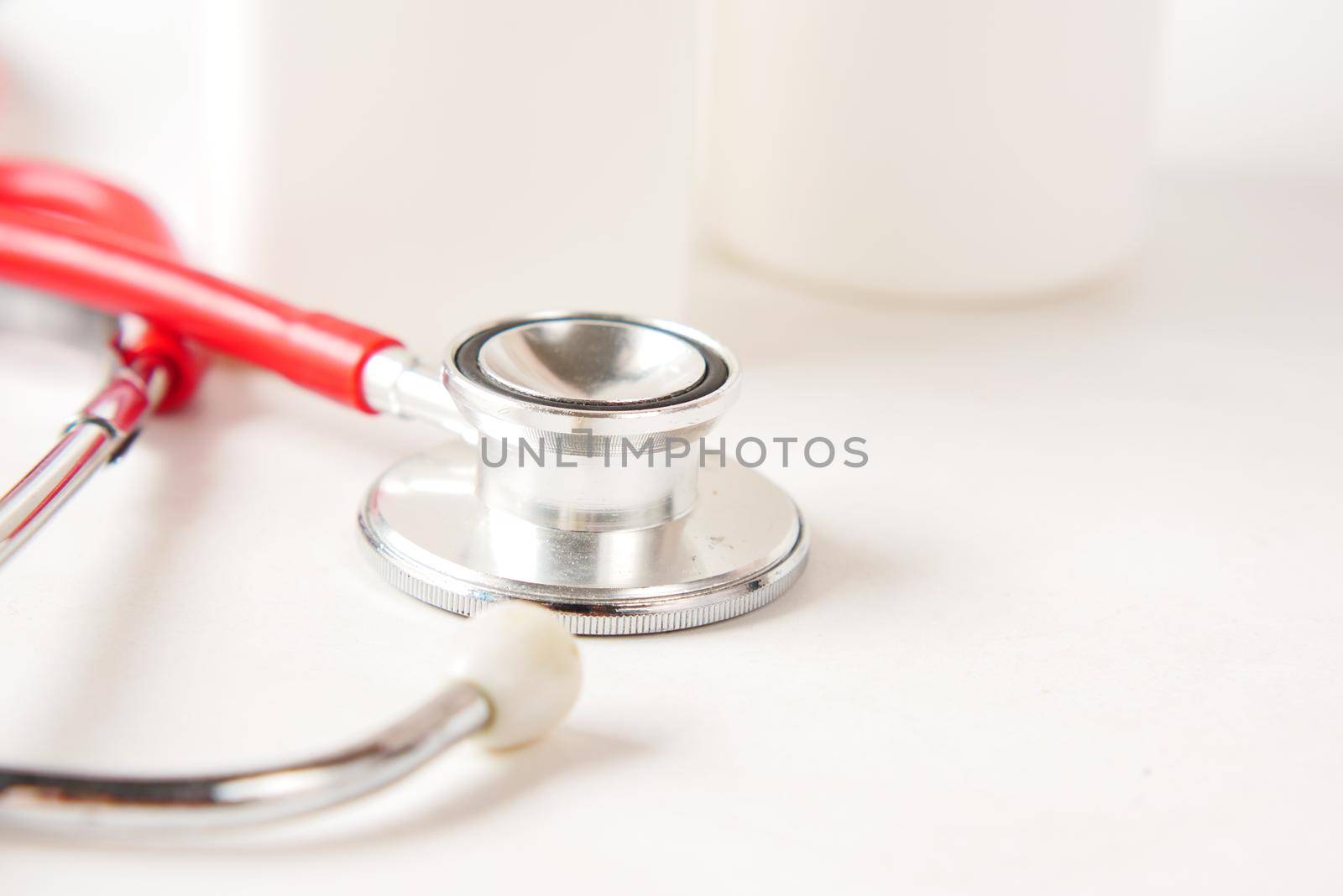 selective focus. stethoscope and pills container on wooden background