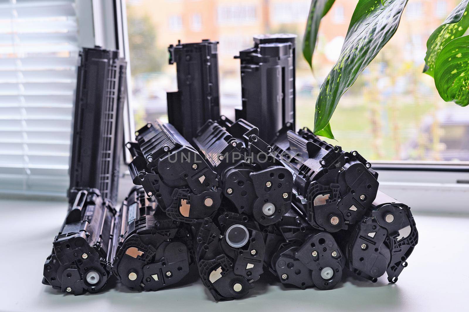 Empty cartridges from the printer stacked on the windowsill of the office. Waste production