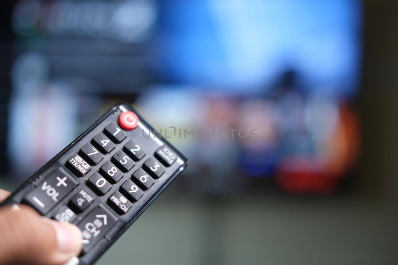 close up of man hand holding tv remote. by towfiq007