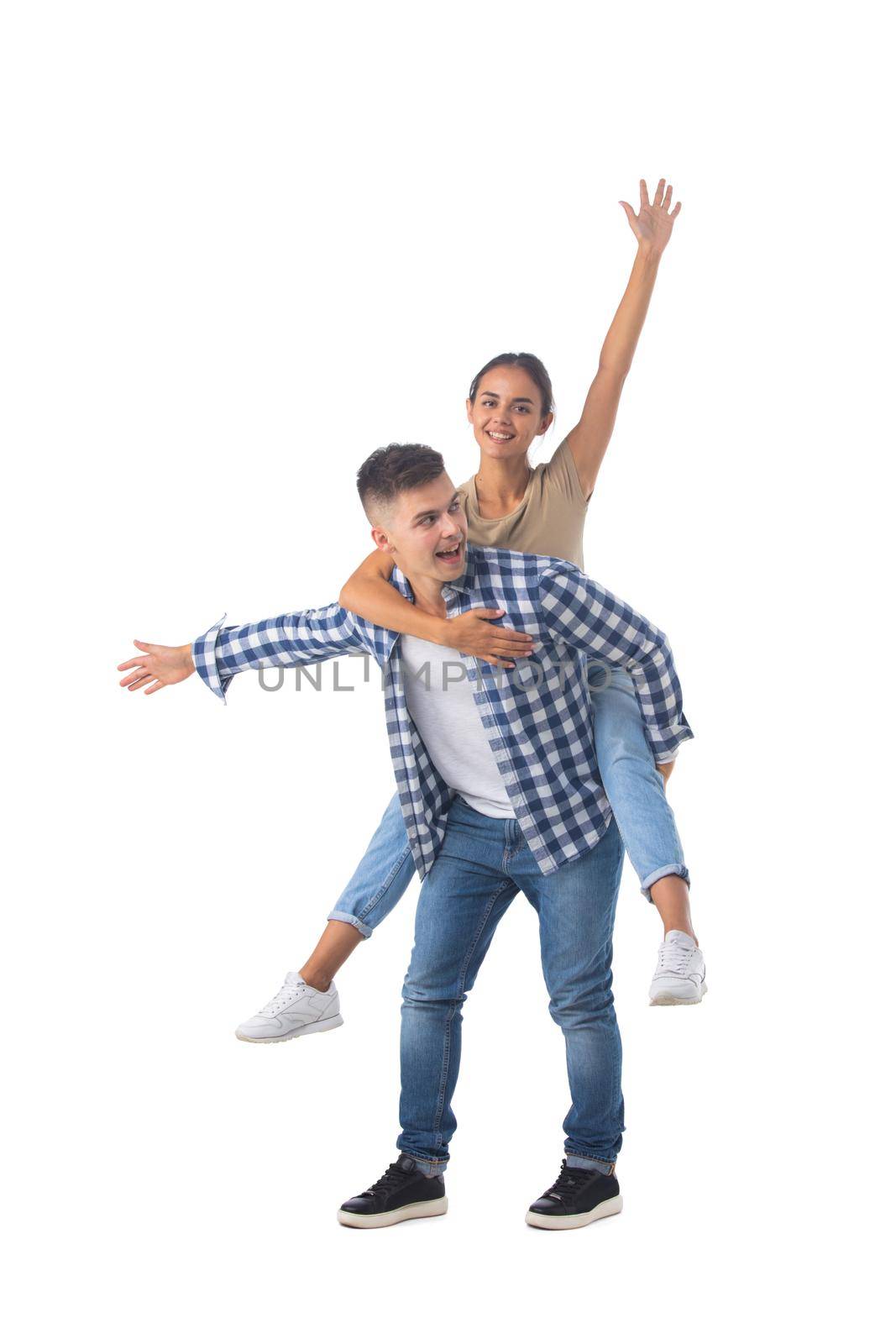 Laughing teen playful couple piggyback ride isolated white background