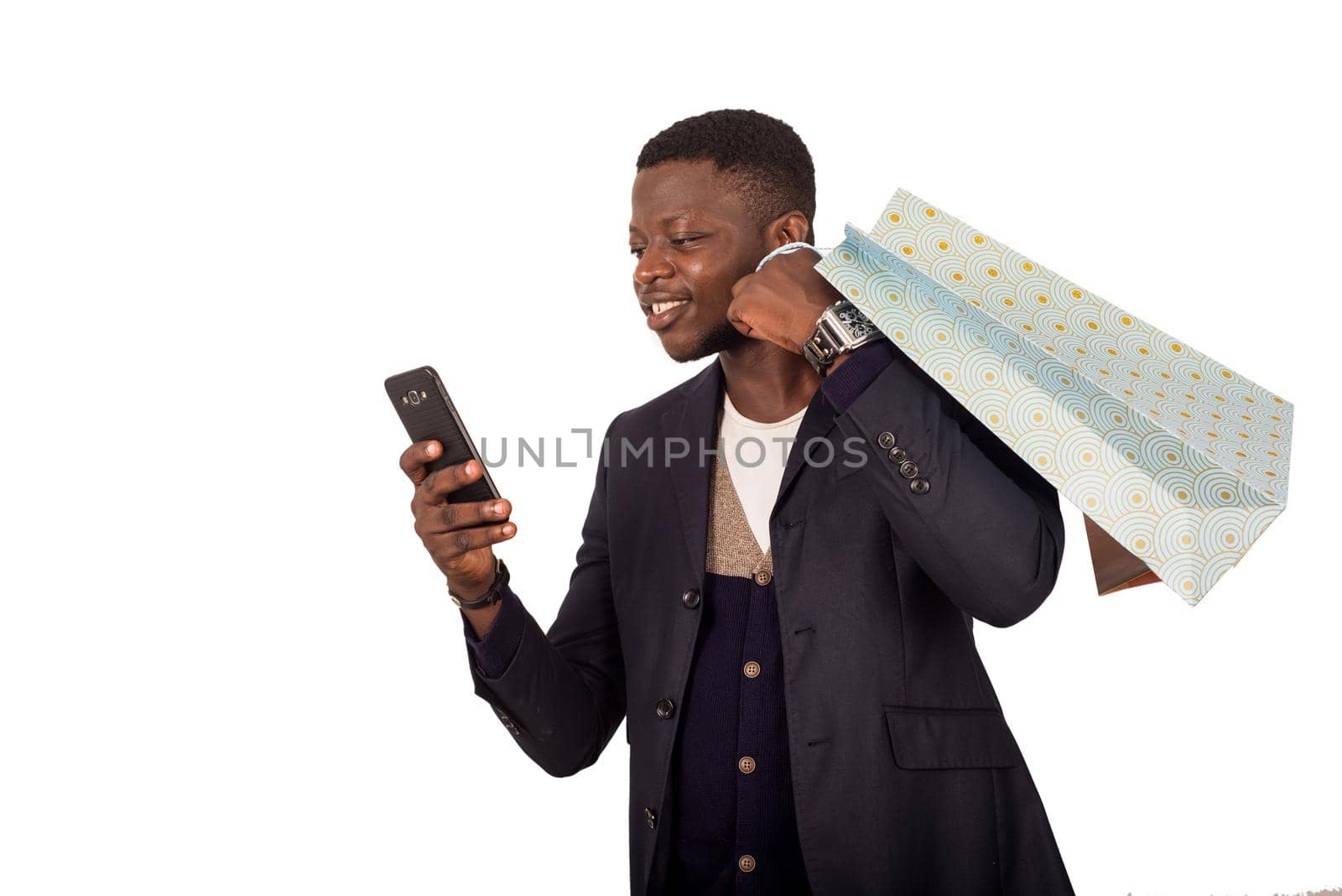 young man with shopping bags talking on smart phone isolated on white background