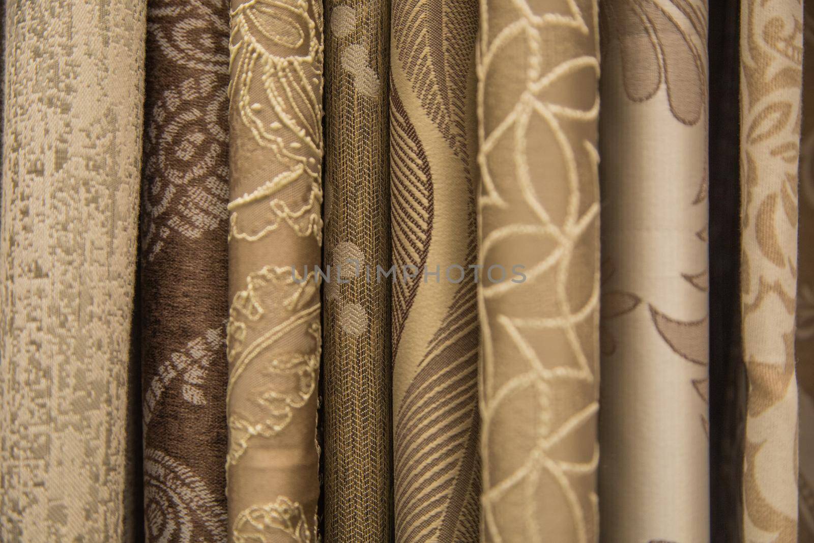 Curtains of different colors and patterns for the room hang horizontally. High quality photo