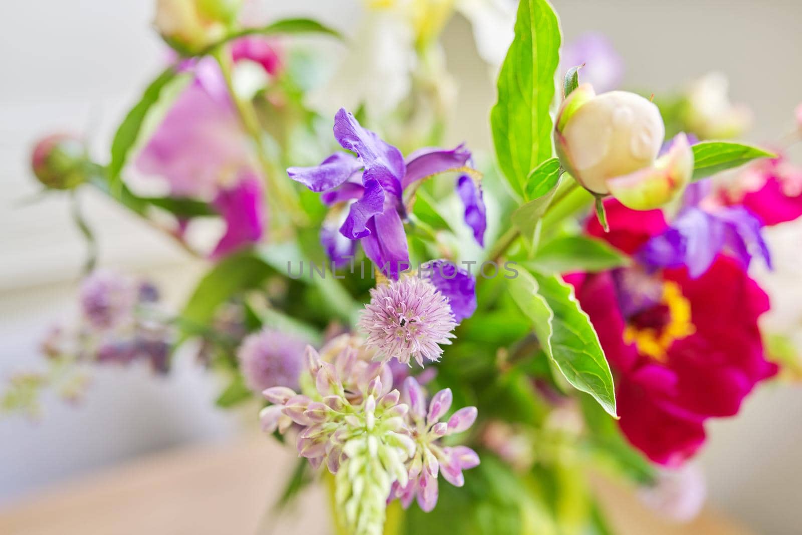 Abstract multicolored floral background texture, close-up flowers and buds peonies irises lupine in defocus, season spring summer, natural beauty, background image