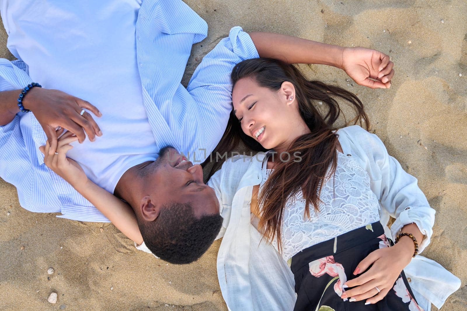 Top view of a young couple in love on the sand by VH-studio