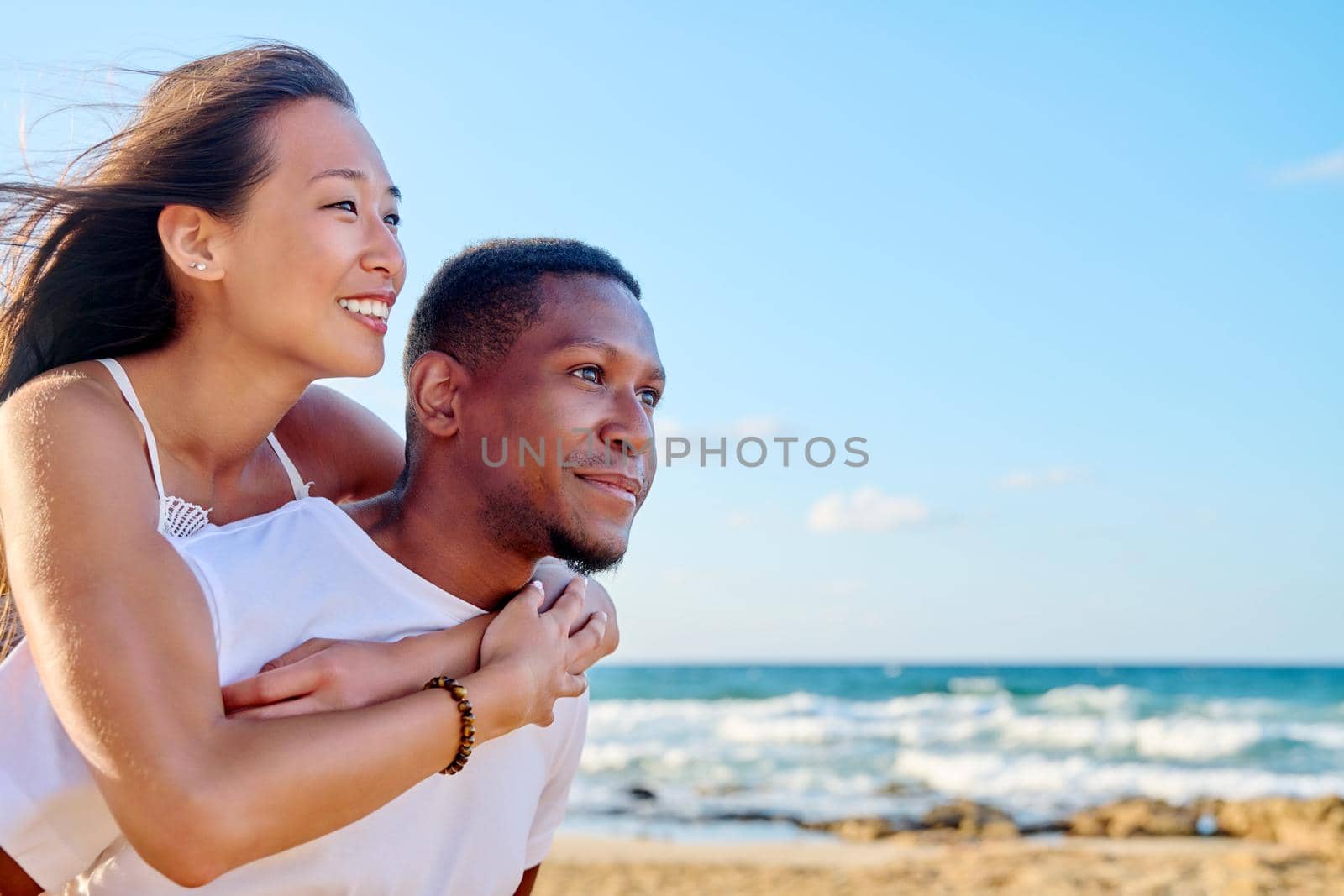 Young beautiful having fun couple on the sea background by VH-studio