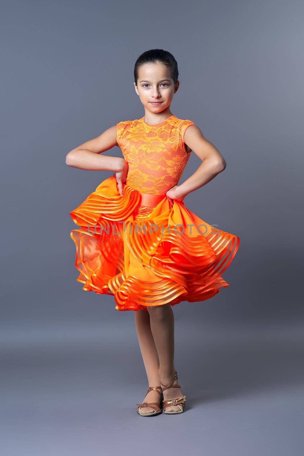 Kids sport dancing, kid girl in orange sport dress posing by VH-studio