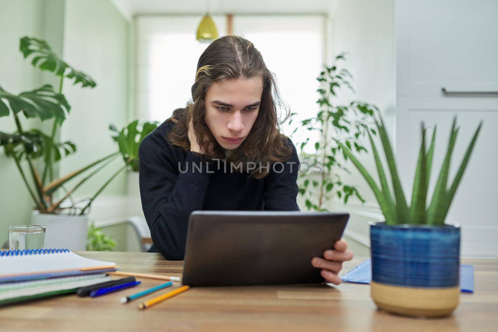 Online lesson, guy student teenager studying at home remotely using digital tablet by VH-studio