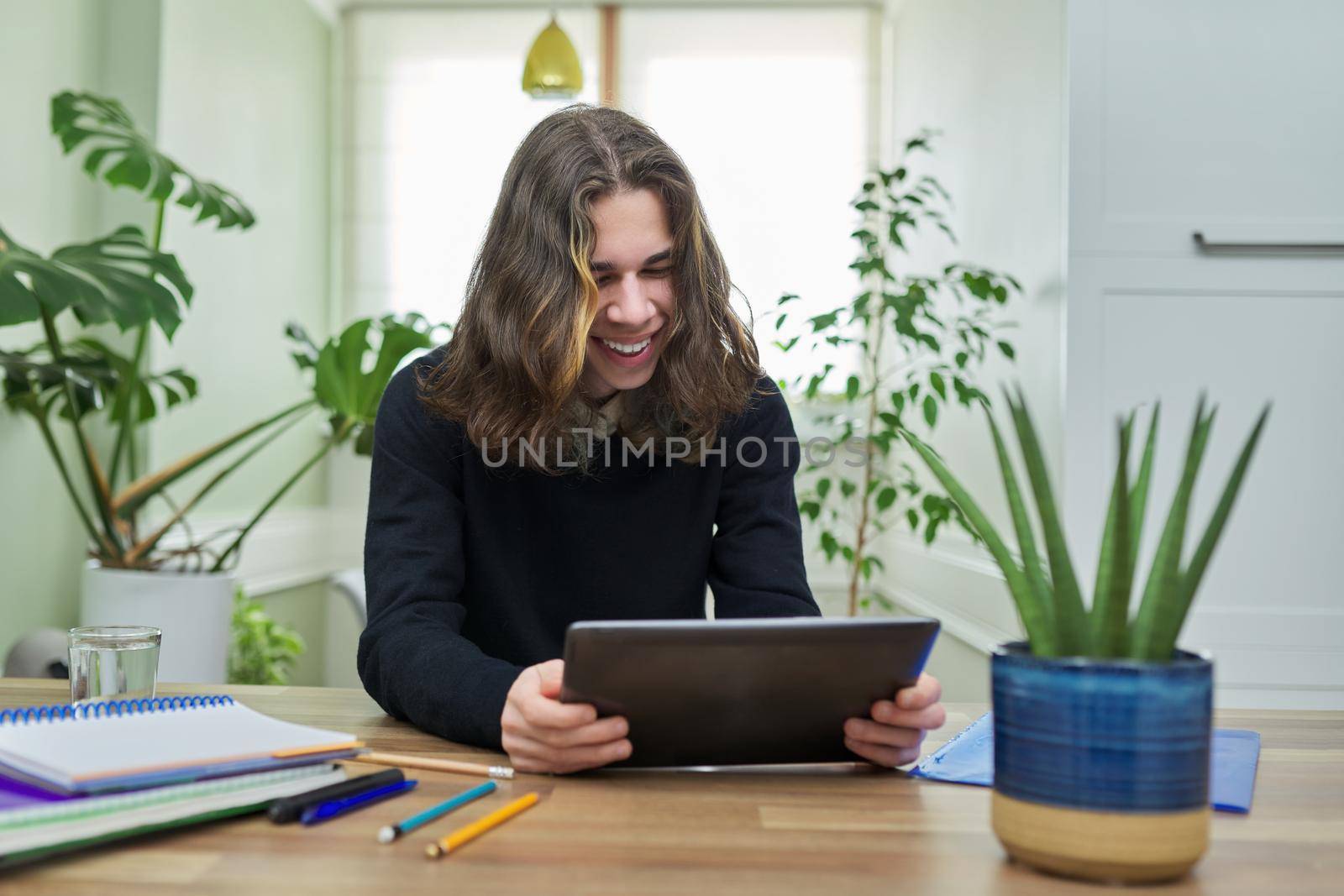 Online lesson, guy student teenager studying at home remotely using digital tablet by VH-studio