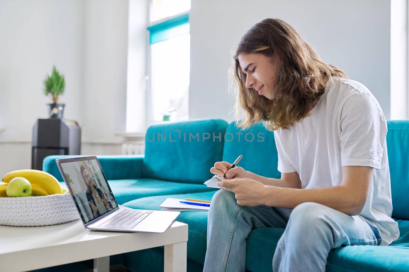 Individual online lesson, teenage boy sitting at home with laptop, studying using remote video consultation, female teacher mentor on computer screen. E-education, technology in teaching, adolescence