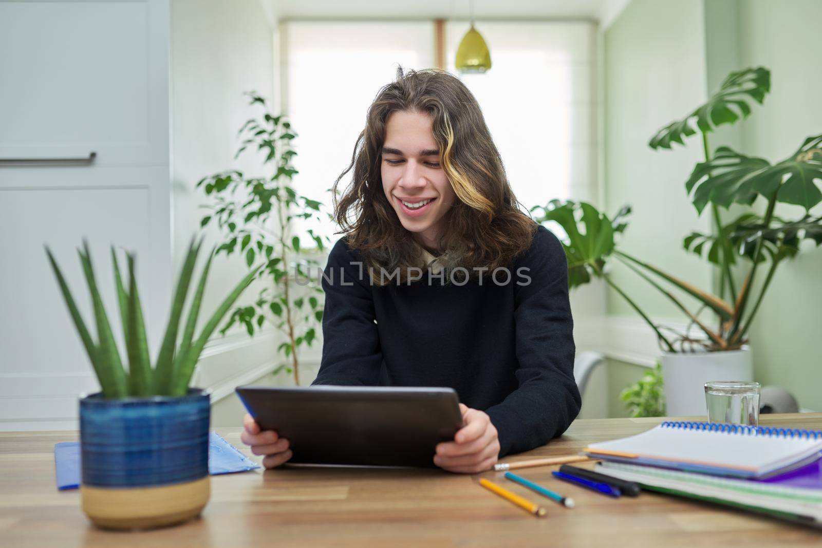 Online lesson, guy student teenager studying at home remotely using digital tablet by VH-studio