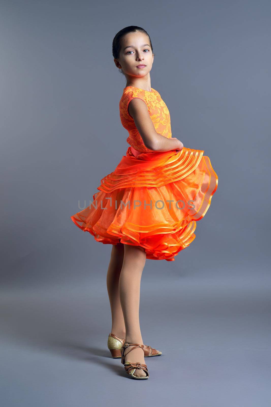 Kids sport dancing, kid girl in orange sport dress posing by VH-studio