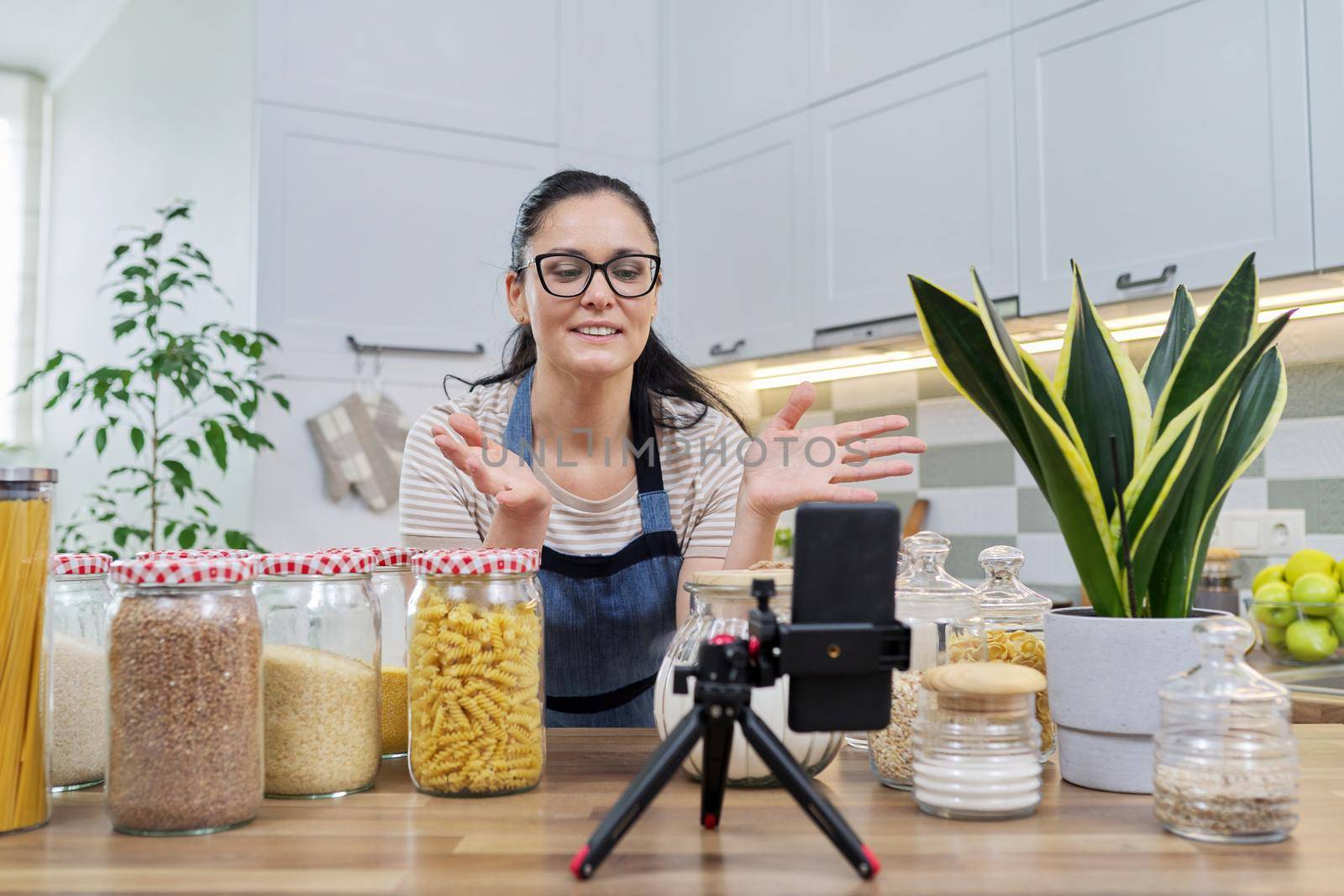 Online broadcast, blog about food, woman in an apron with jars of cereals by VH-studio