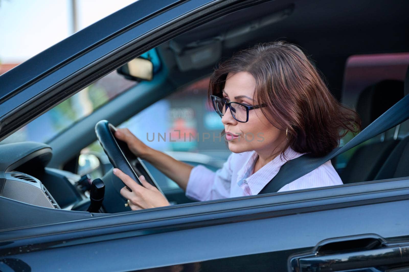 Middle-aged beautiful woman driver driving a car by VH-studio