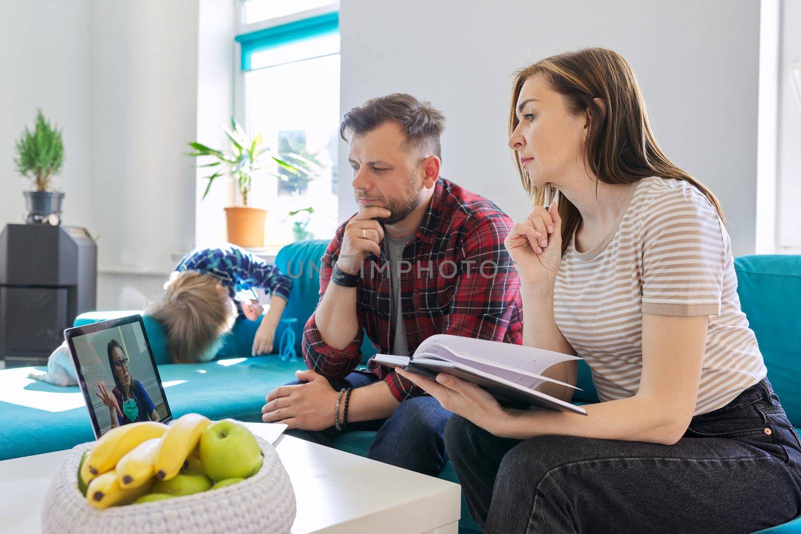 Online medical consultation, family sitting at home on sofa in living room with laptop by VH-studio