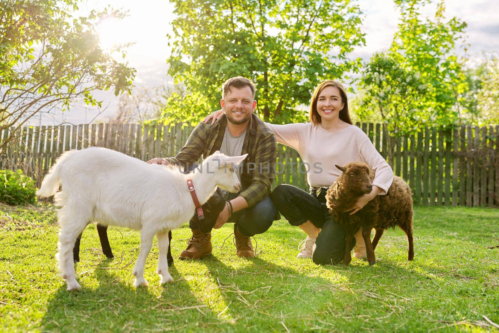 Small farm with ouessant sheep and goat, portrait of family couple of farm owners with animals, eco tourism, countryside, rural scene, domestic animals
