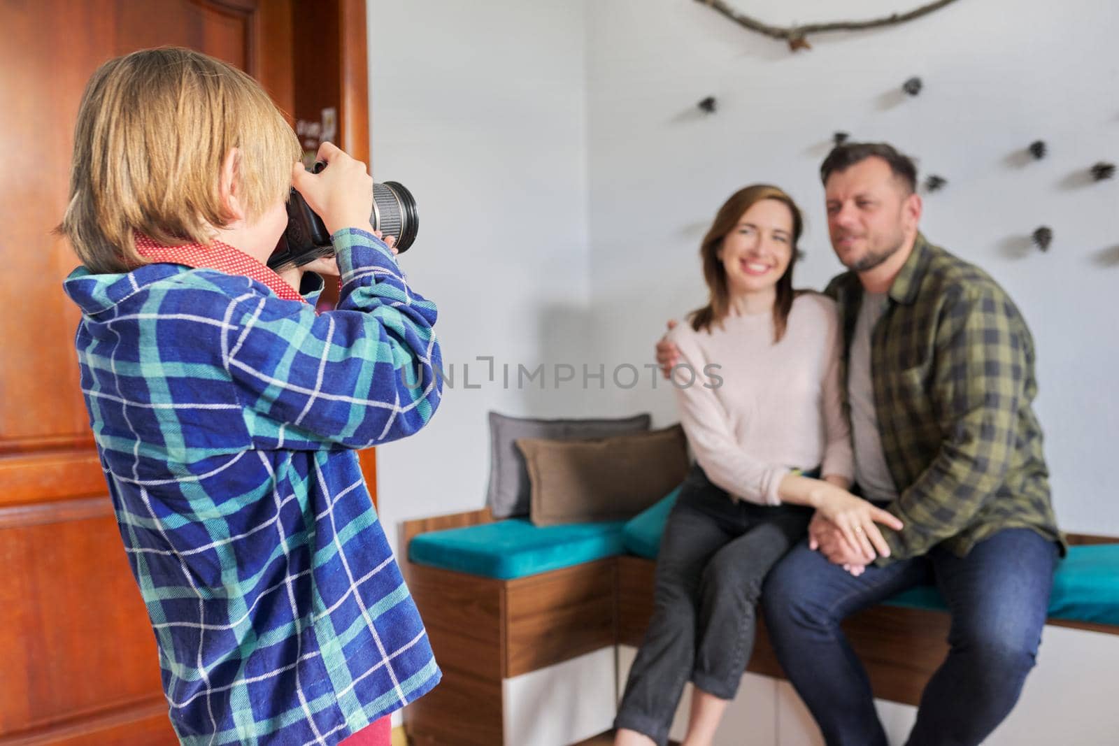 Happy family at home, little son with camera taking photo of hugging parents. Family, lifestyle, relationships, leisure, home life concept