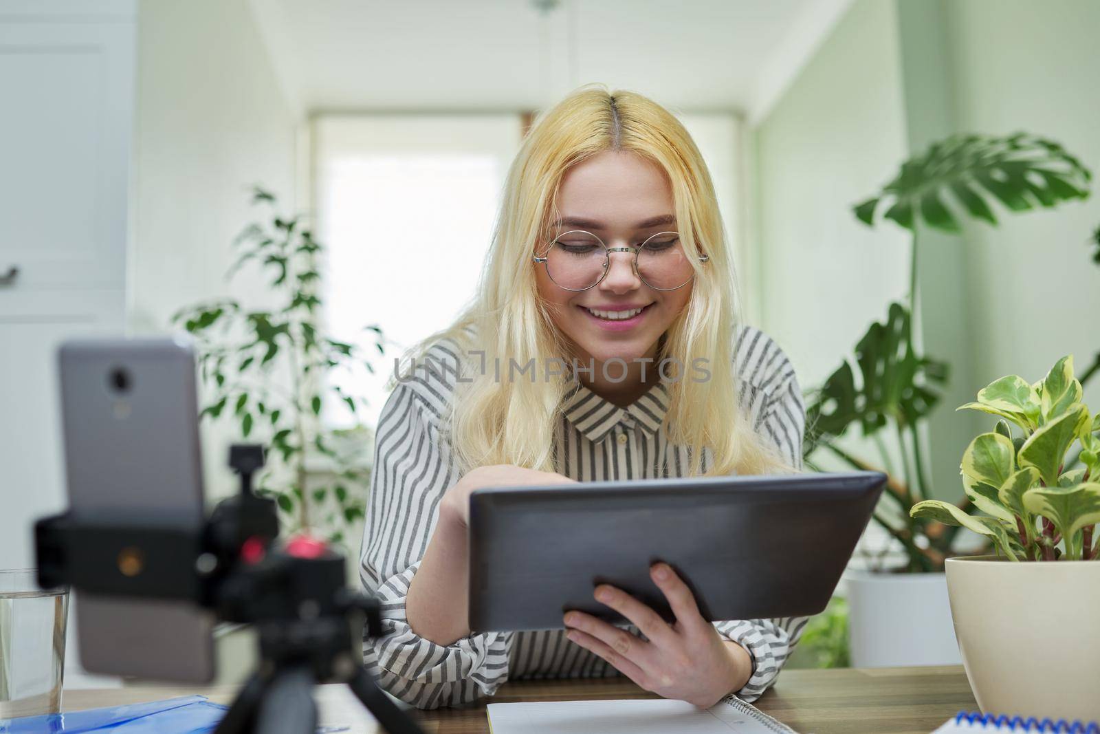 Online lesson, distance learning, e-learning. Female teenager student talking looking at smartphone webcam using digital tablet. High school, technology in education