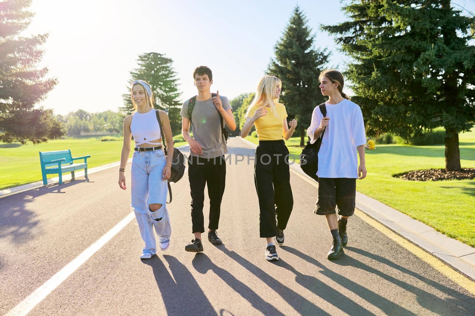 Outdoor, four teenagers walking together on road by VH-studio