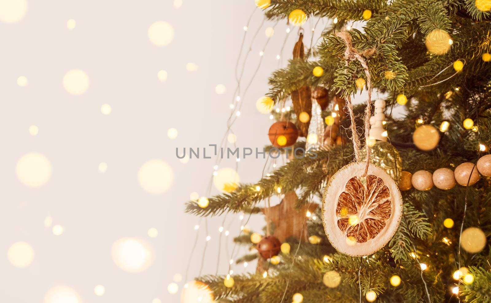 Christmas tree decorated in scandinavian style, rustic ornament and defocused lights. Stock photo with copy space.