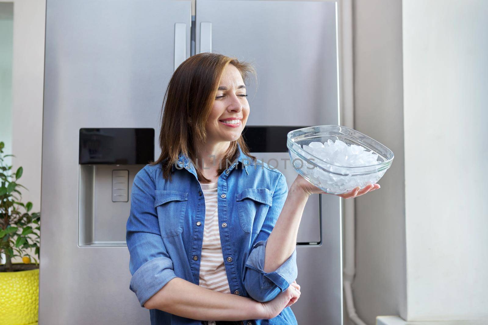 Woman with bowl with ice cubes for cooling food by VH-studio