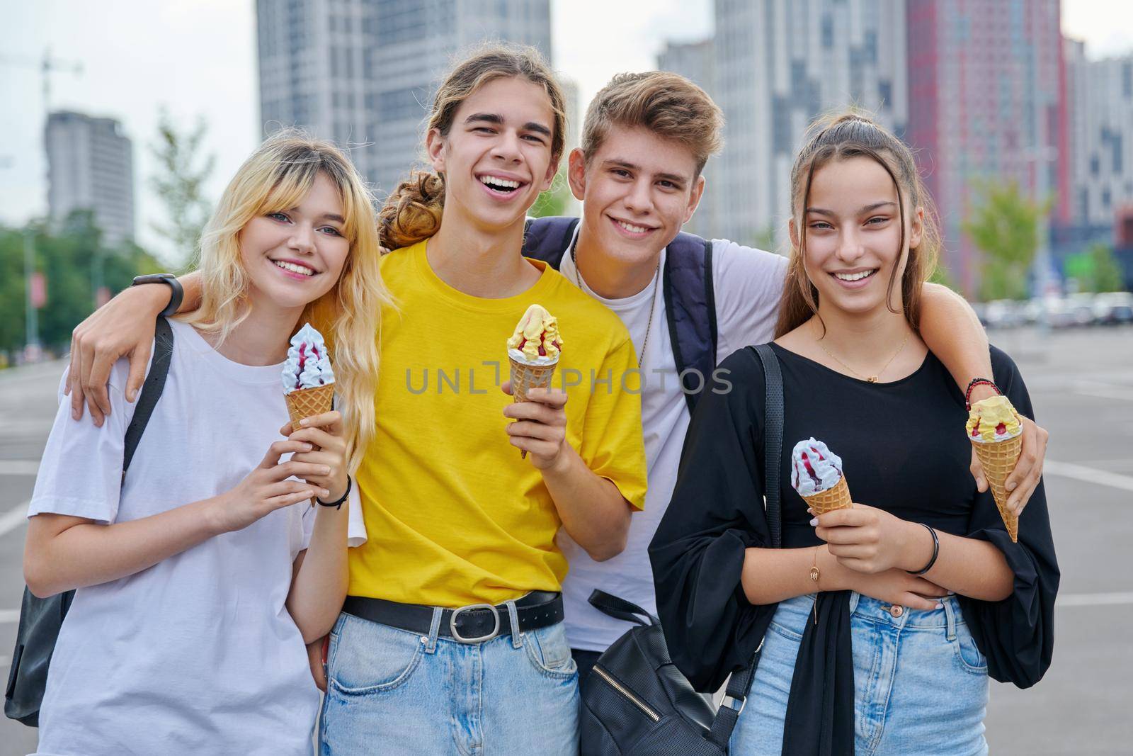 Group portrait of happy teenagers having fun with ice cream. Four smiling young people embracing together in city, lifestyle, friendship, adolescence, summer, leisure, youth concept