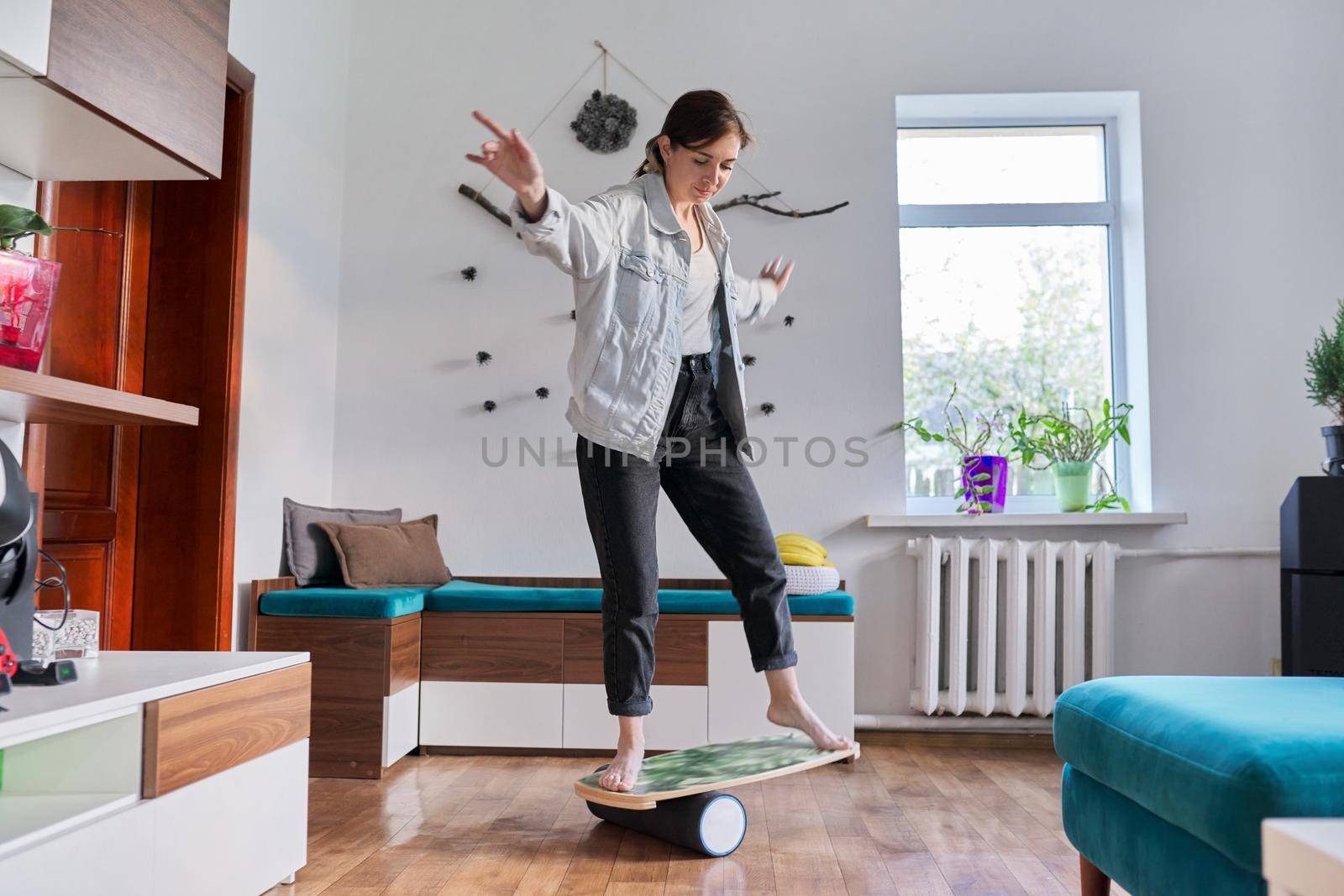 Middle-aged woman on fitness balance board. Active healthy lifestyle, sport at home, health, middle aged people concept