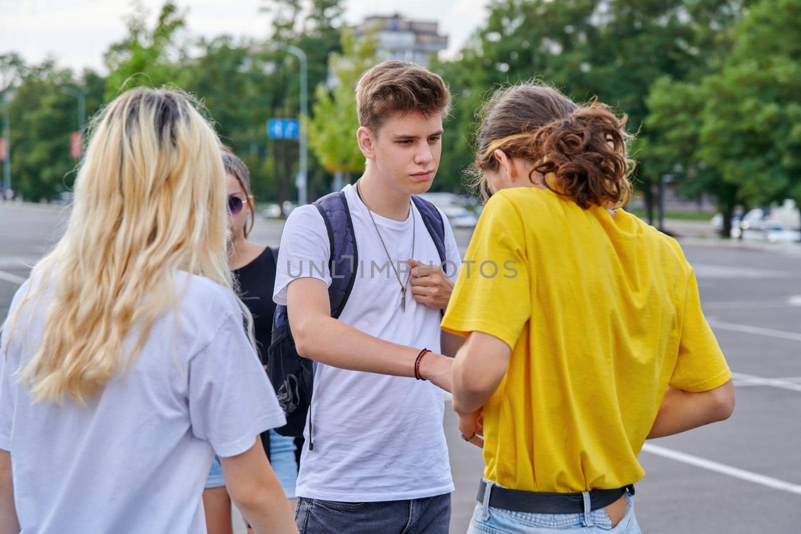 Group of teenagers in city, serious guy talking to friend. Teenagers, lifestyle, adolescence, modern youth concept