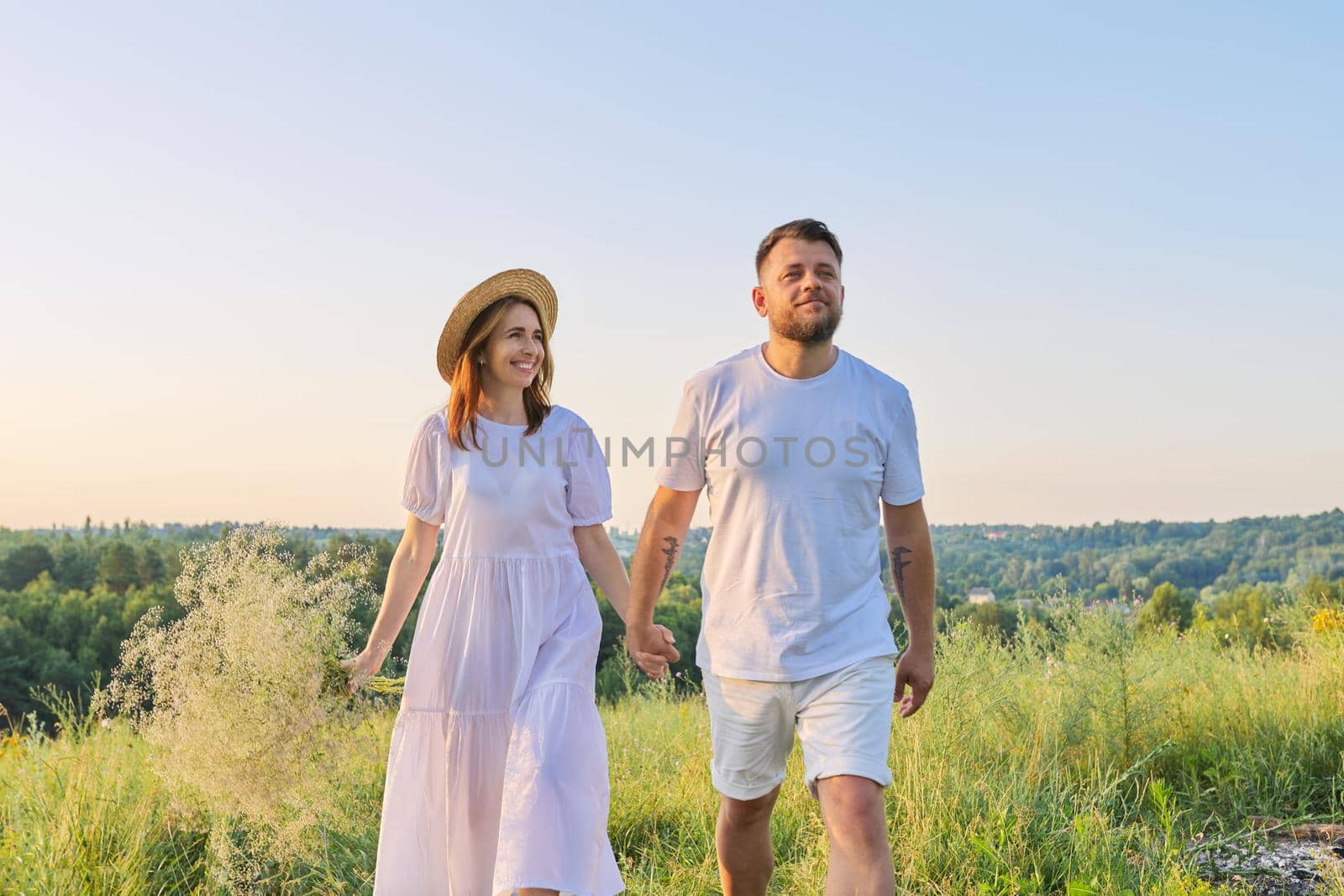 Happy romantic middle age couple, walking together holding hands by VH-studio