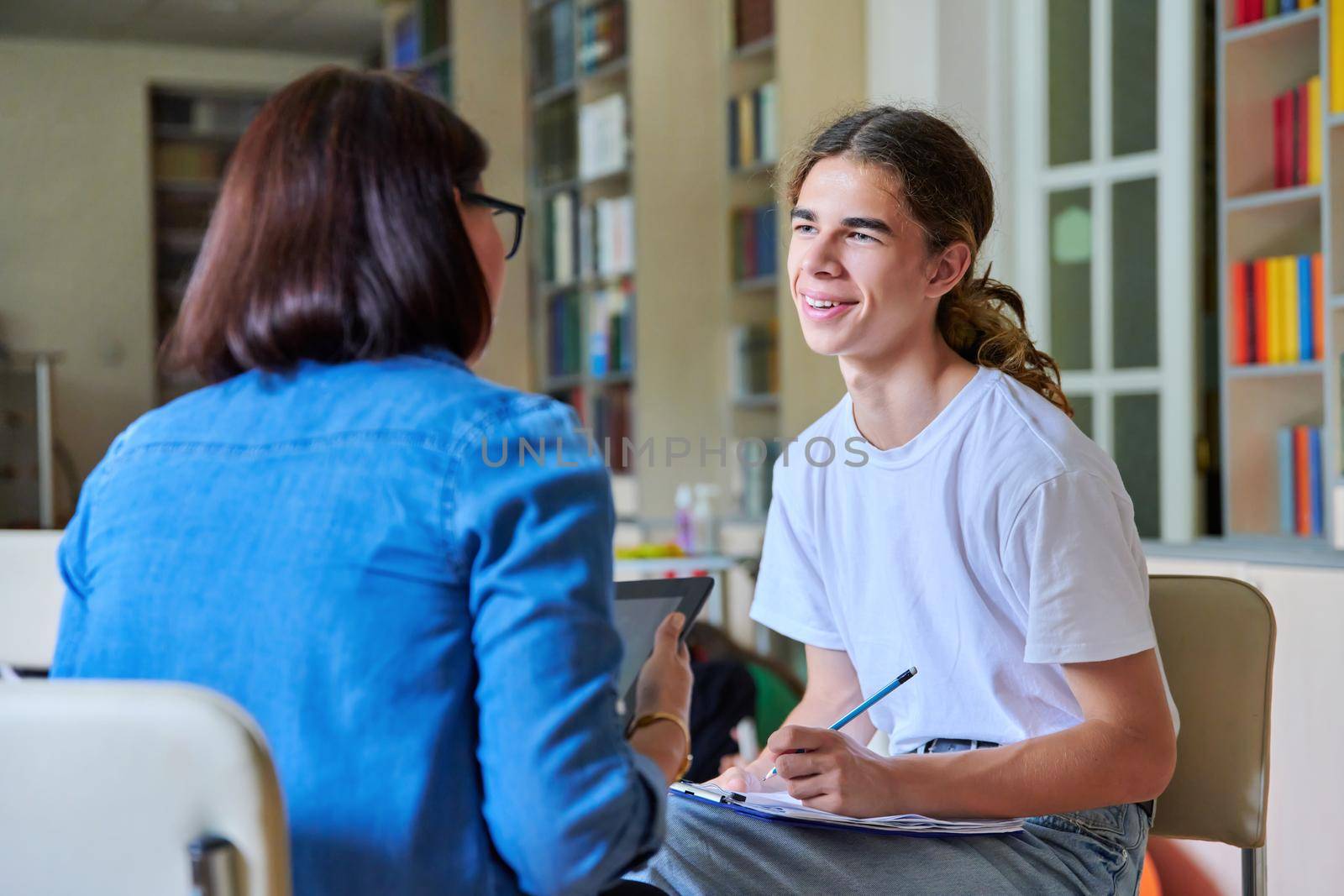 Woman school psychologist teacher talking and helping student, male teenager by VH-studio