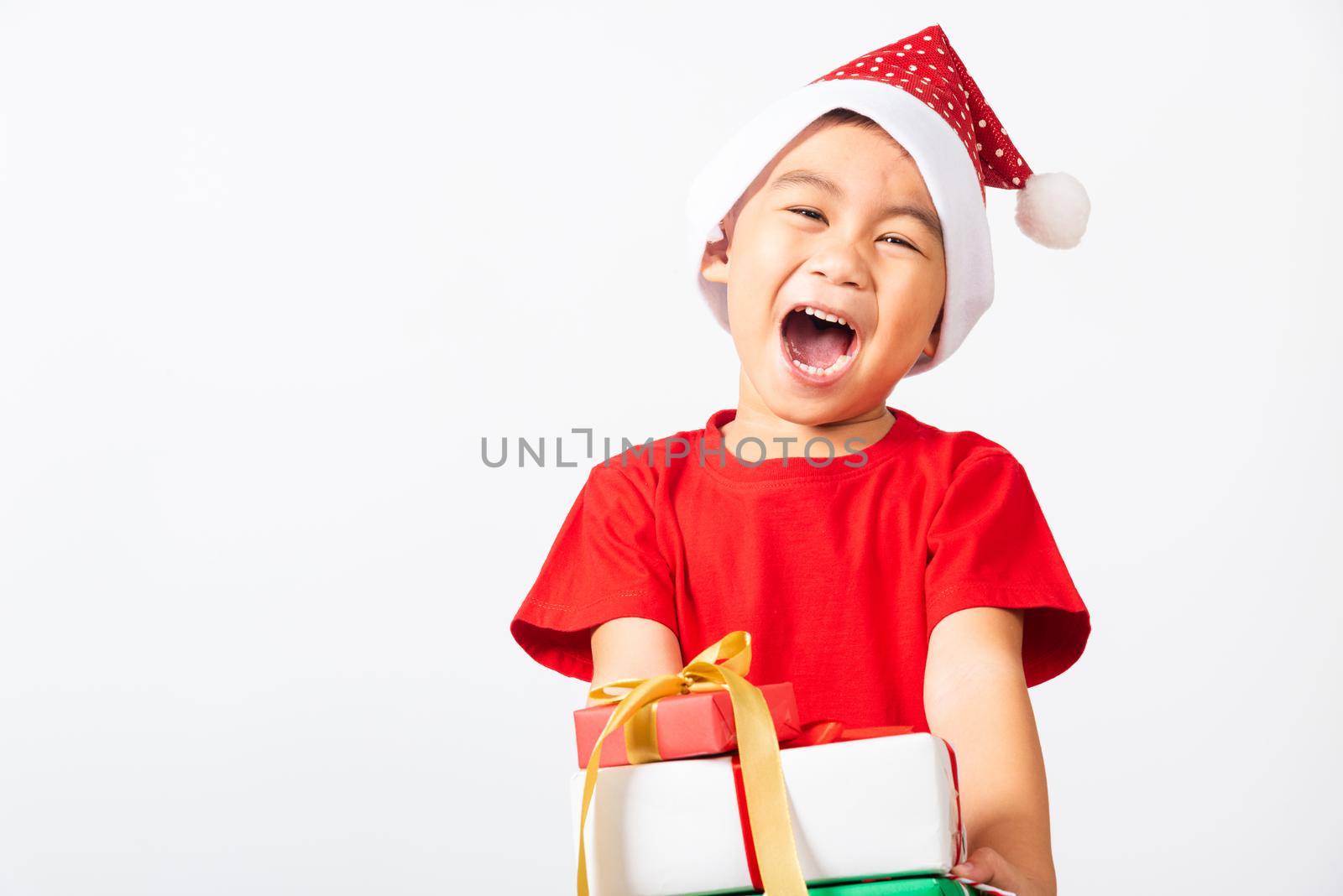 Asian little child cute boy smile and excited, Kid dressed in red Santa Claus hat hold gift box on hands concept of holiday Christmas Xmas day or Happy new year isolated on white background