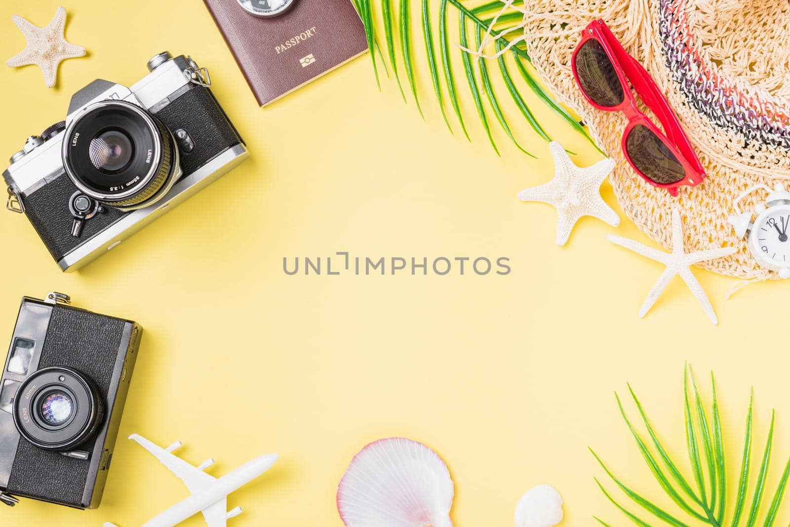 Flat lay top view mockup retro camera films, hat, airplane, starfish traveler tropical beach accessories on a yellow background with copy space, Vacation summer travel and business trip concept