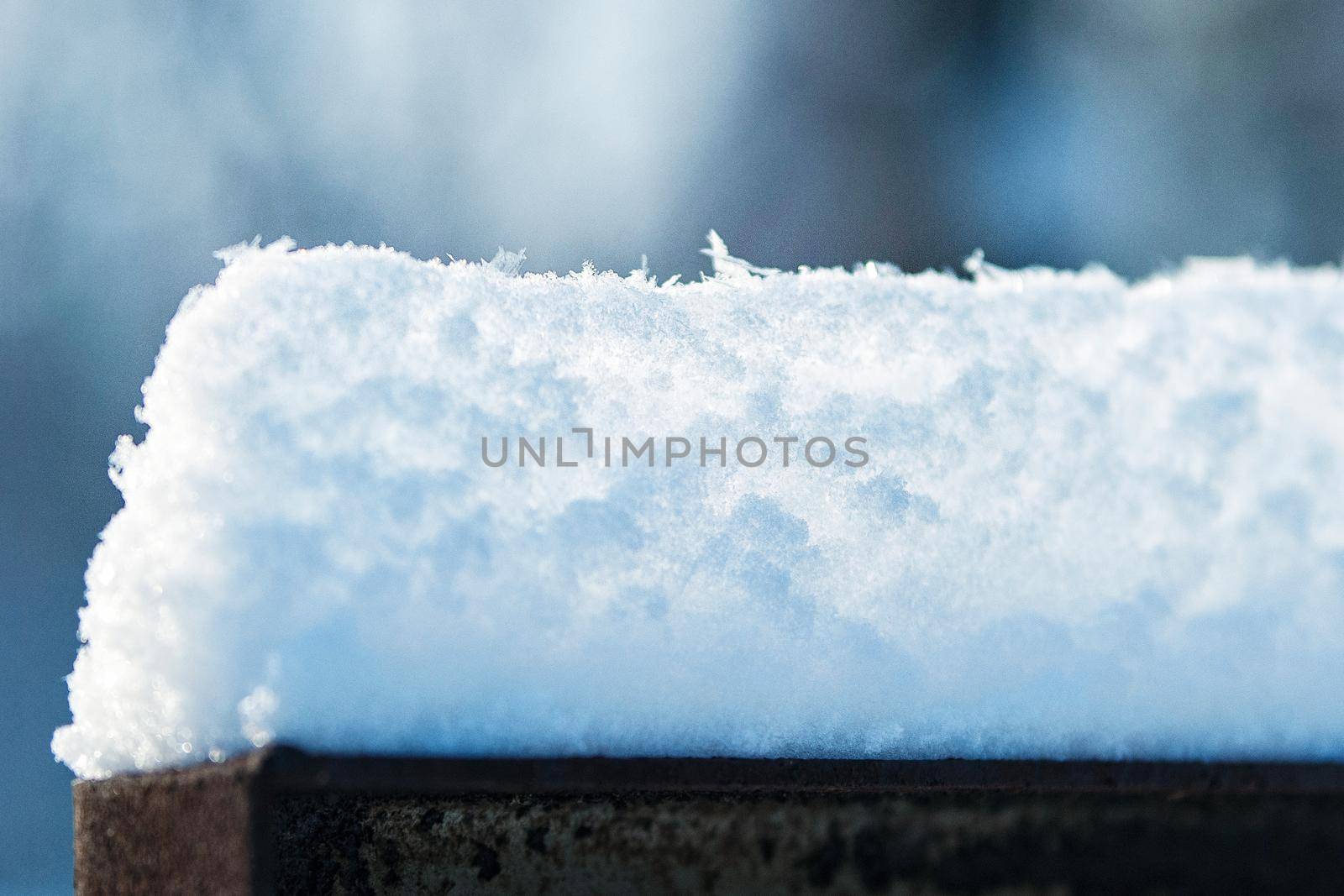 snow caps on the slabs of the village fence