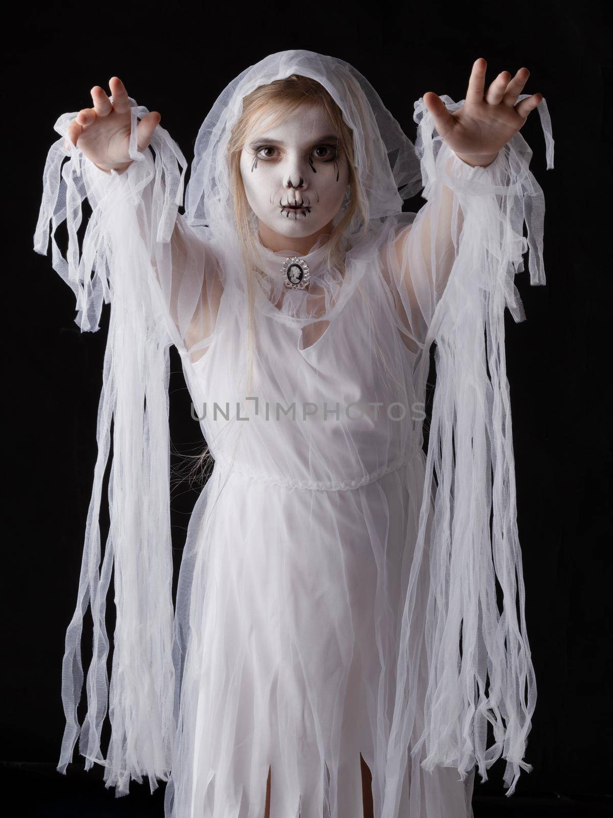 Little girl in Halloween ghost costume walking on you, studio isolated on black background