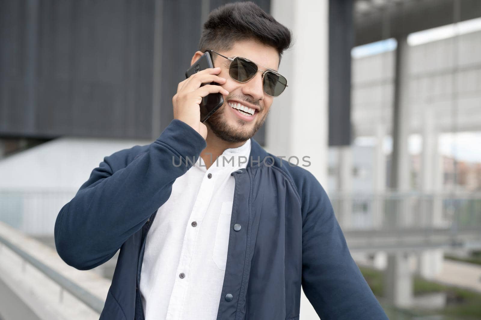 Handsome Man talking on cellphone at modern office building. High quality photo